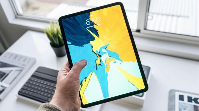 Drži iPad Pro s svetlim ozadjem